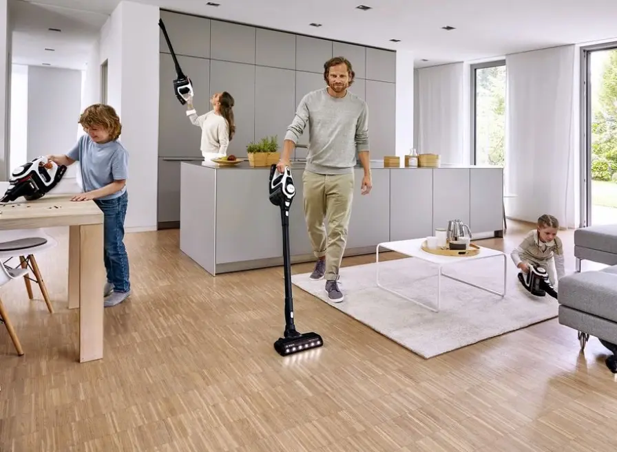 Bosch cordless stick vacuum cleaner used in various ways in the kitchen and living room.