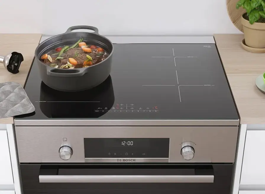 Bosch vrijstaand inductiefornuis waarop een pan met eten staat te garen.