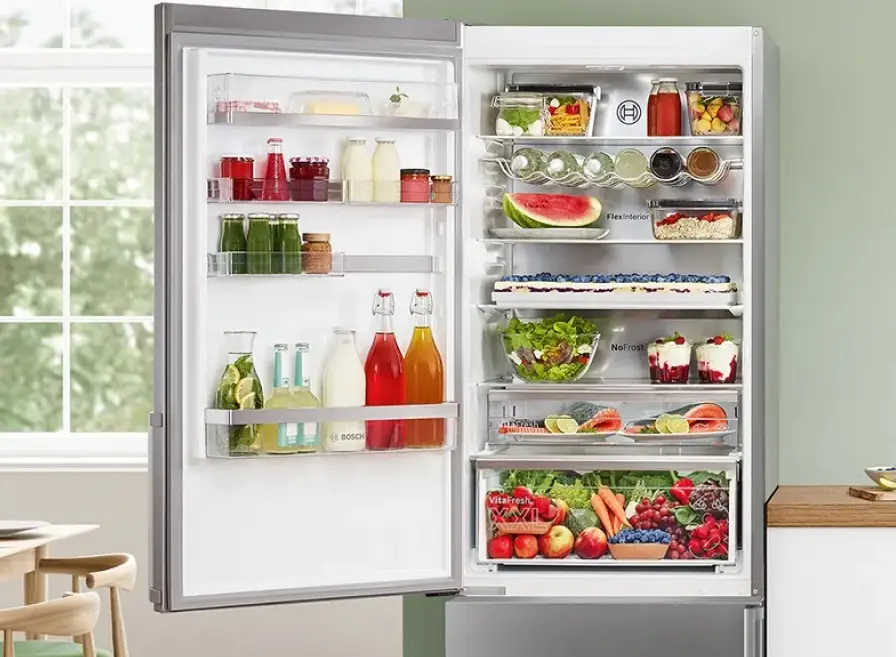 Rijkgevulde vrijstaande Bosch koelkast met open deur.