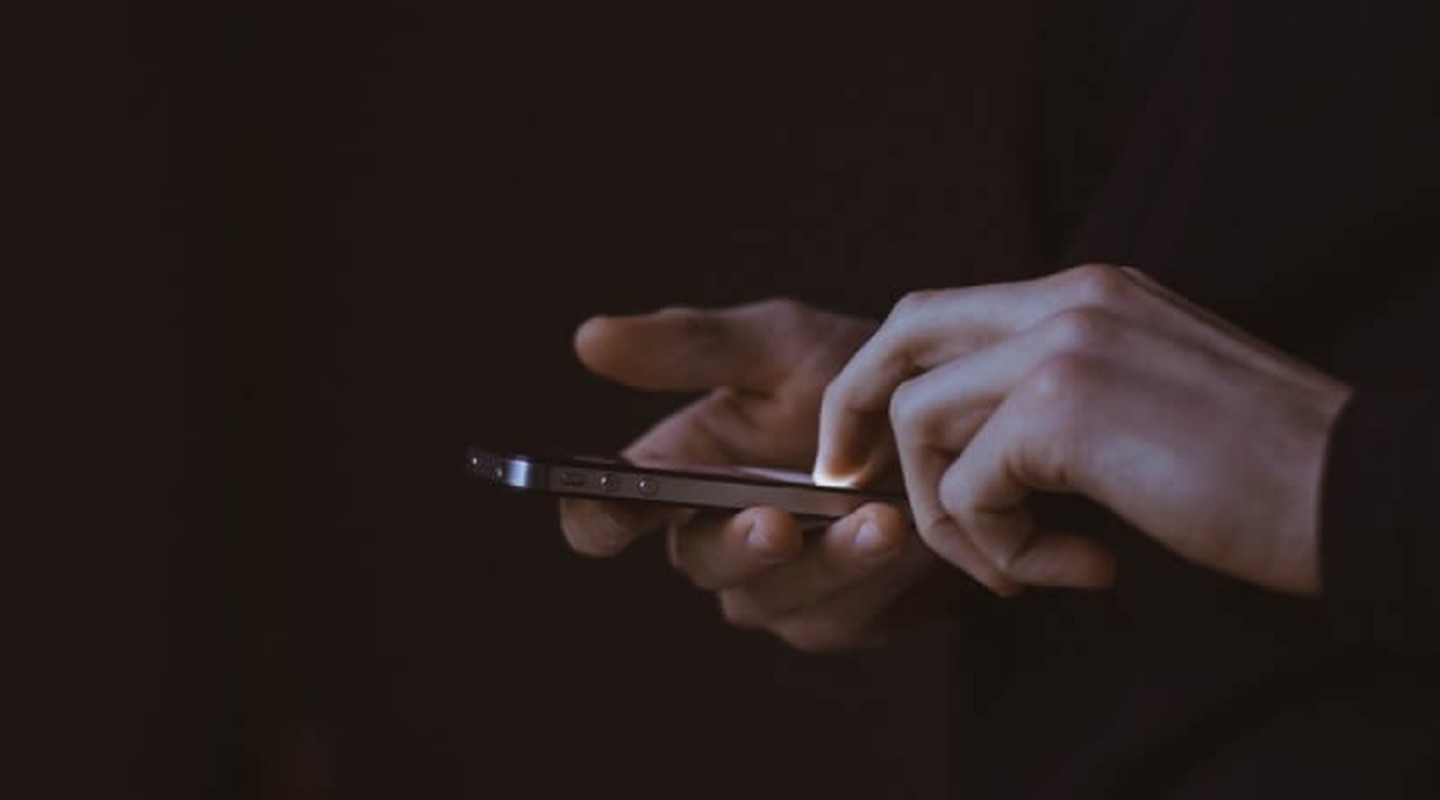 photograph of hands using a mobile phone