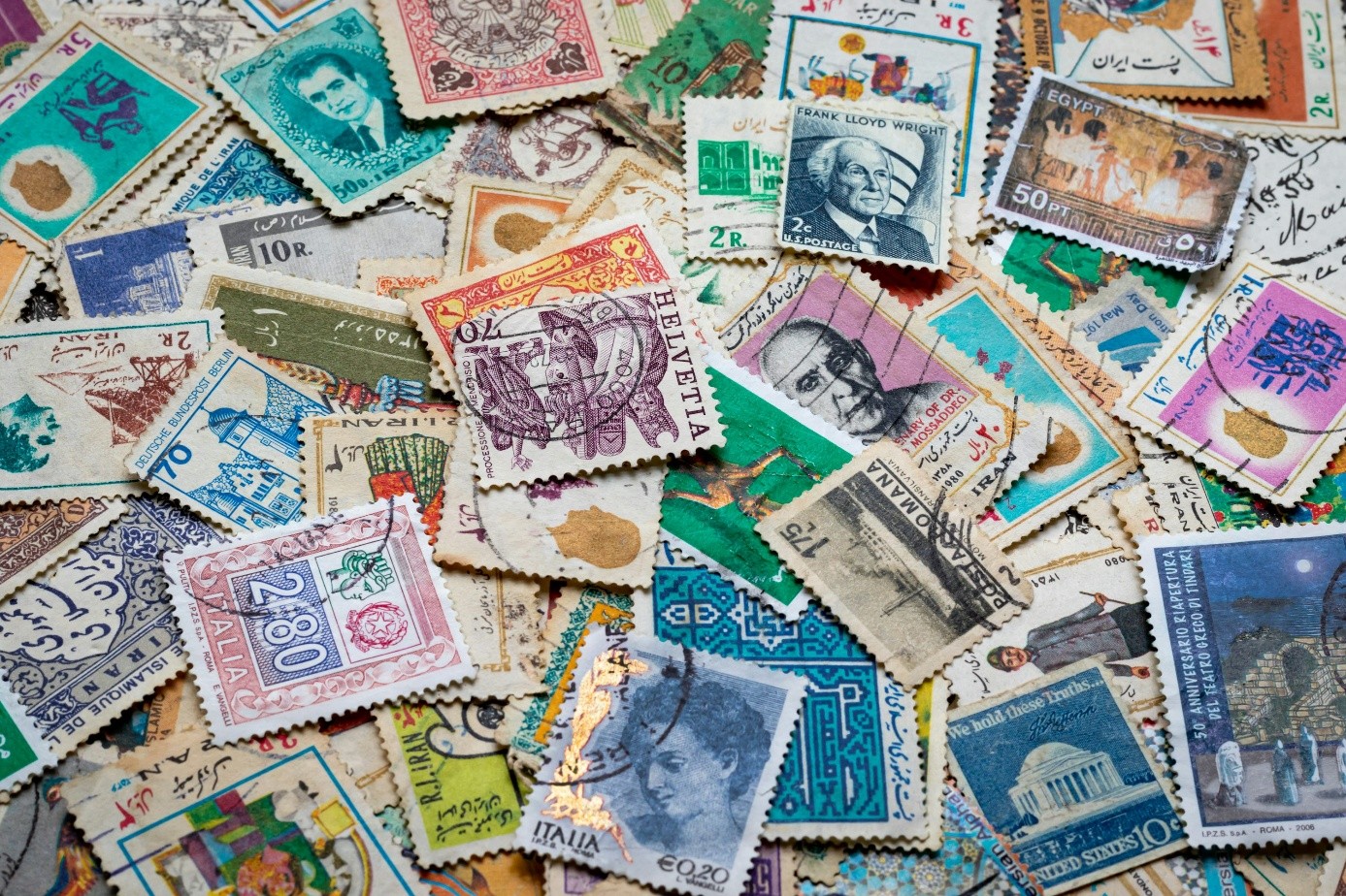 A colorful assortment of vintage postage stamps from various countries, featuring diverse designs, colors, and portraits.