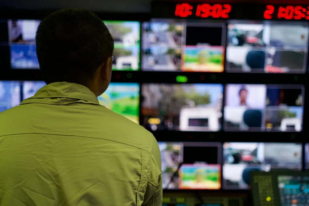 Operator watching a wall of monitoring screens