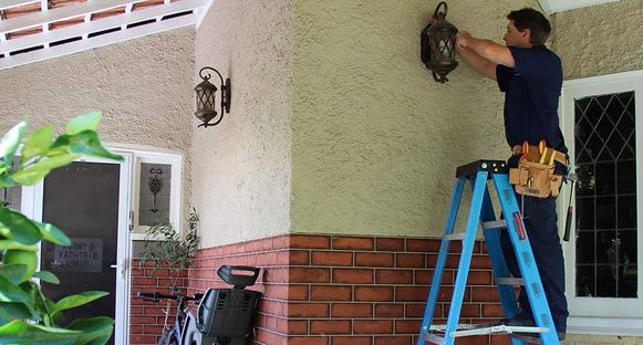 Handyman fixing outside house light