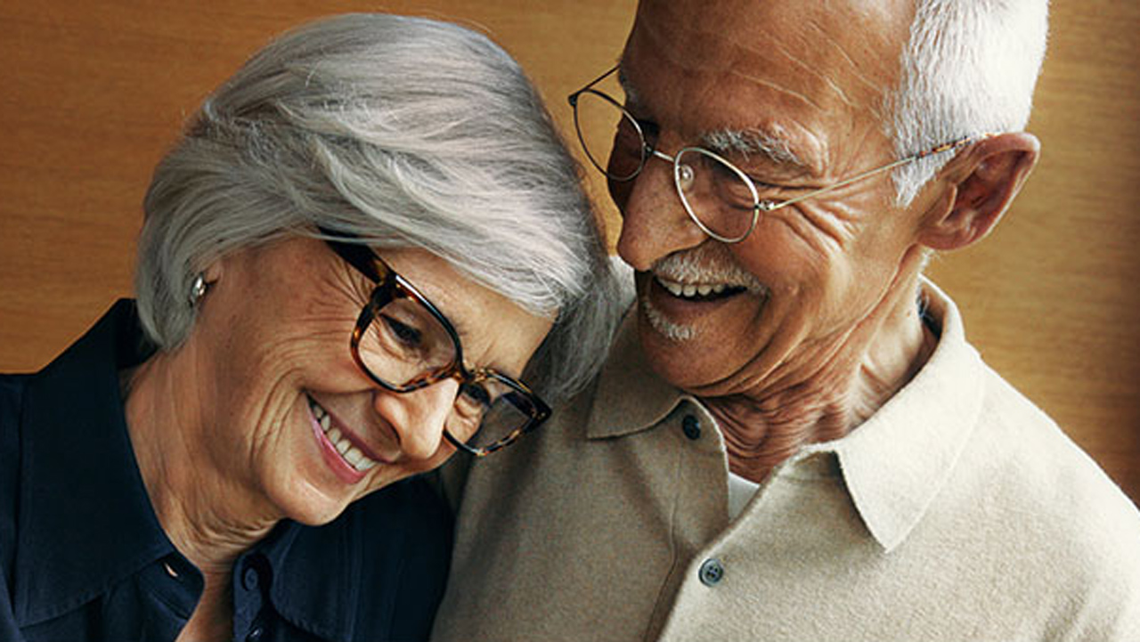 Ein älteres Ehepaar, beide tragen eine Brille und lächeln, mit dem Text „Unsere Zufriedenheits-Garantie” und einem Button mit der Aufschrift „Jetzt mehr erfahren”.