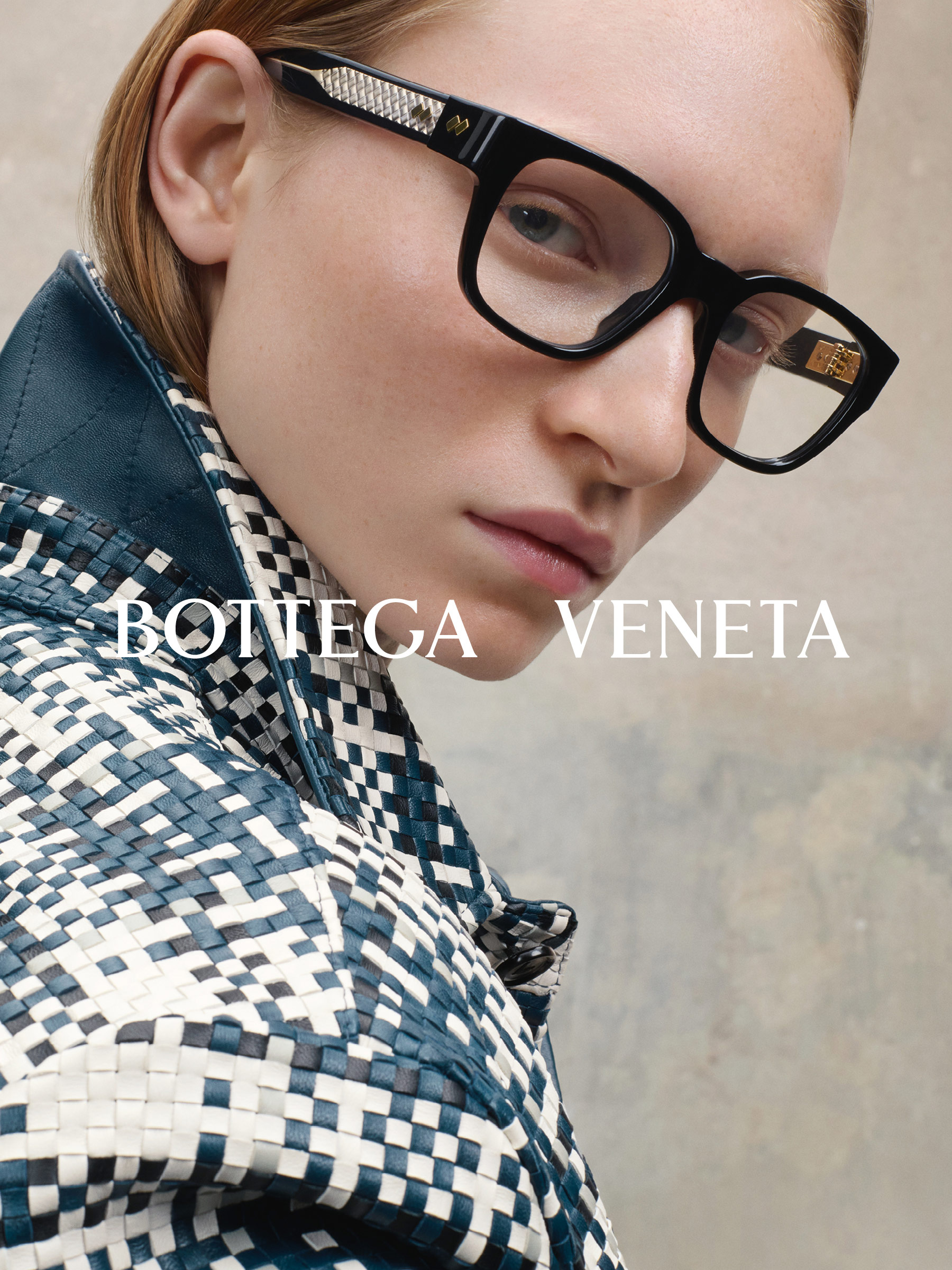 Osoba w czarnych okularach i wzorzystej kurtce z napisem „Bottega Veneta” nad nią.