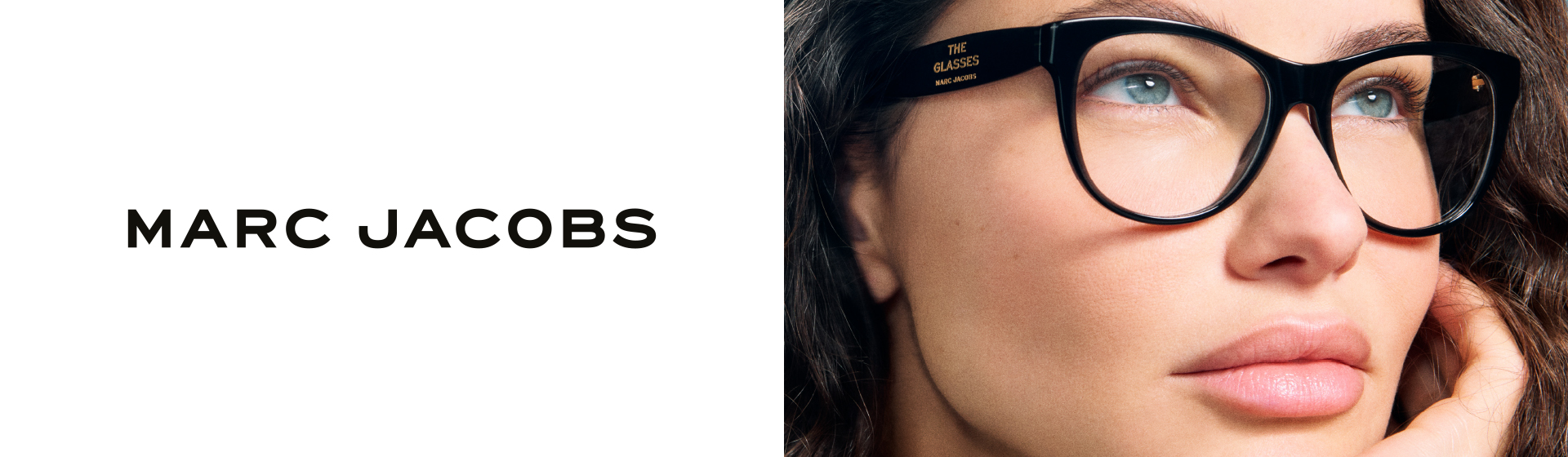 Zbliżenie osoby w okularach z czarną oprawką, patrzącej w górę, z logo „Marc Jacobs”.