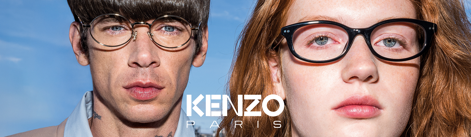 Gros plan sur des mannequins masculins et féminins portant des lunettes, expression neutre, devant un ciel bleu avec le logo « KENZO PARIS ».