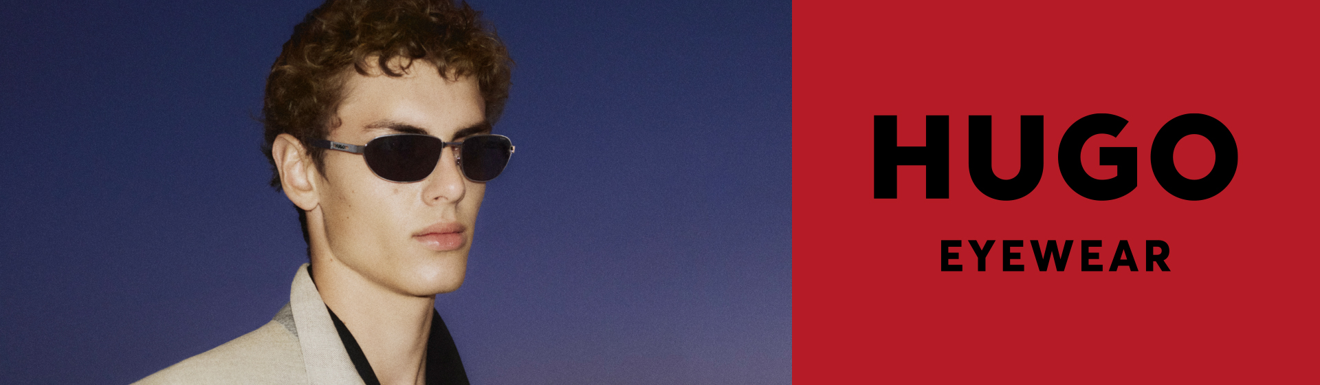 Muž v slunečních brýlích před modrým pozadím s nápisem „HUGO Eyewear”.