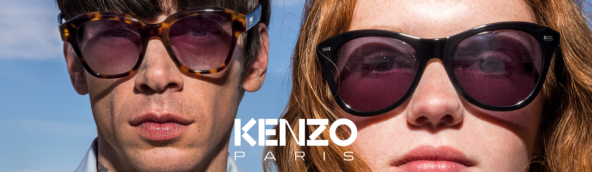 Gros plan sur un homme et une femme portant des lunettes de soleil stylées devant un ciel bleu, avec le logo « KENZO PARIS ».
