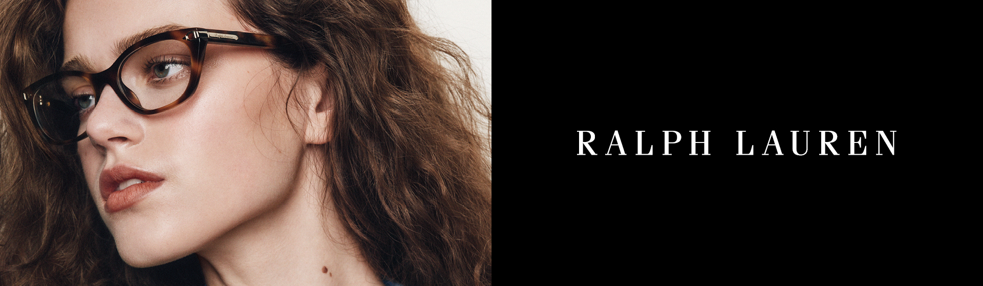 Eine Person mit braunen Locken und einer Brille. Es ist das „Ralph Lauren“-Logo zu sehen.