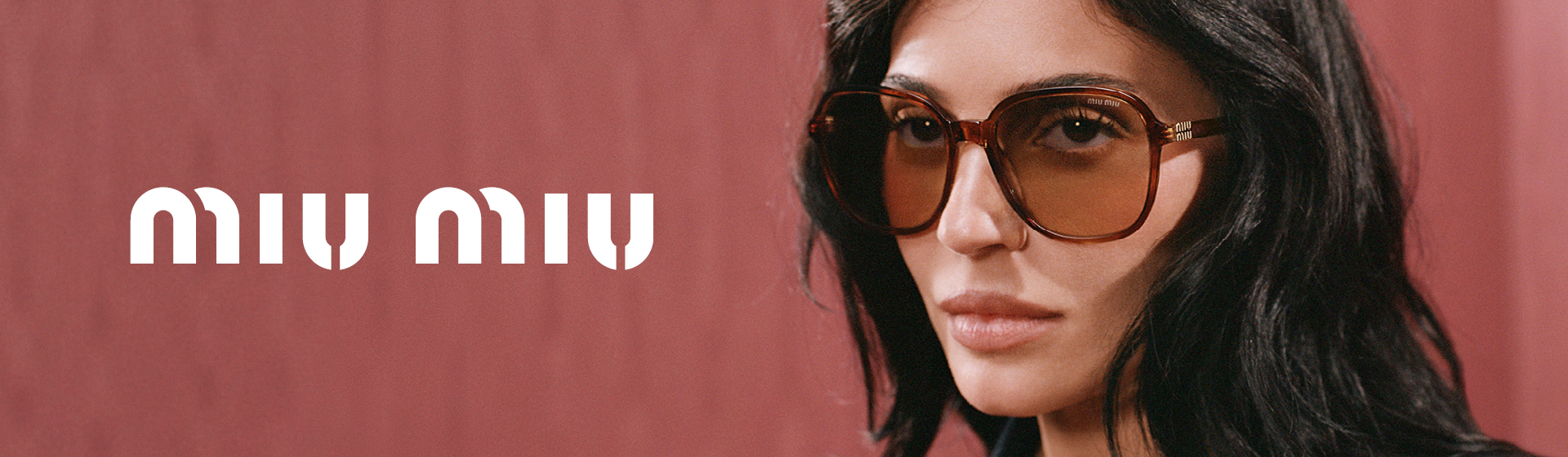 Frau mit langen dunklen Haaren, die eine große braune Sonnenbrille trägt, neben dem Schriftzug „Miu Miu” auf einem gedeckten roten Hintergrund.