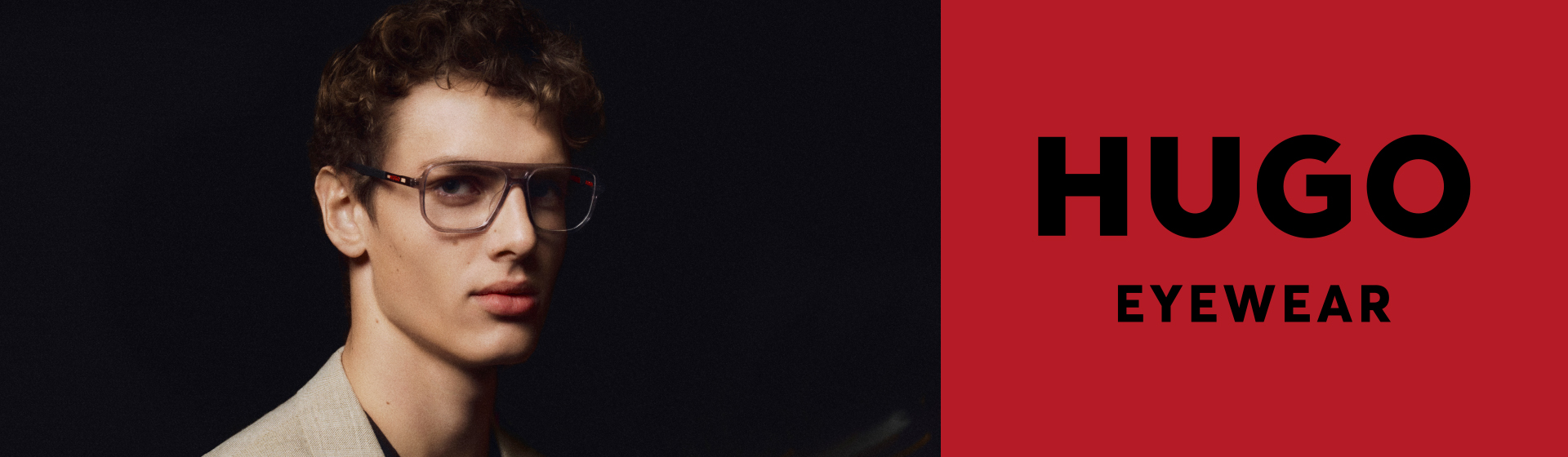 Osoba w okularach patrząca w obiektyw aparatu na ciemnym tle. Z boku napis „HUGO Eyewear”.