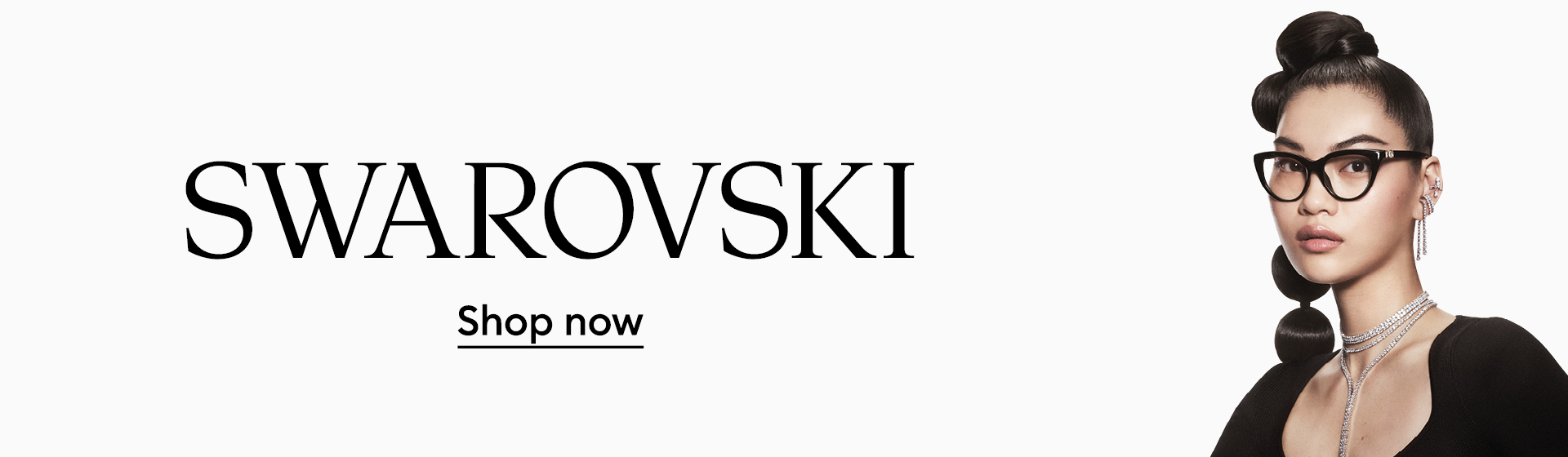 Una donna indossa occhiali cat-eye di Swarovski. Sotto il logo Swarovski c’è scritto “Shop now”.