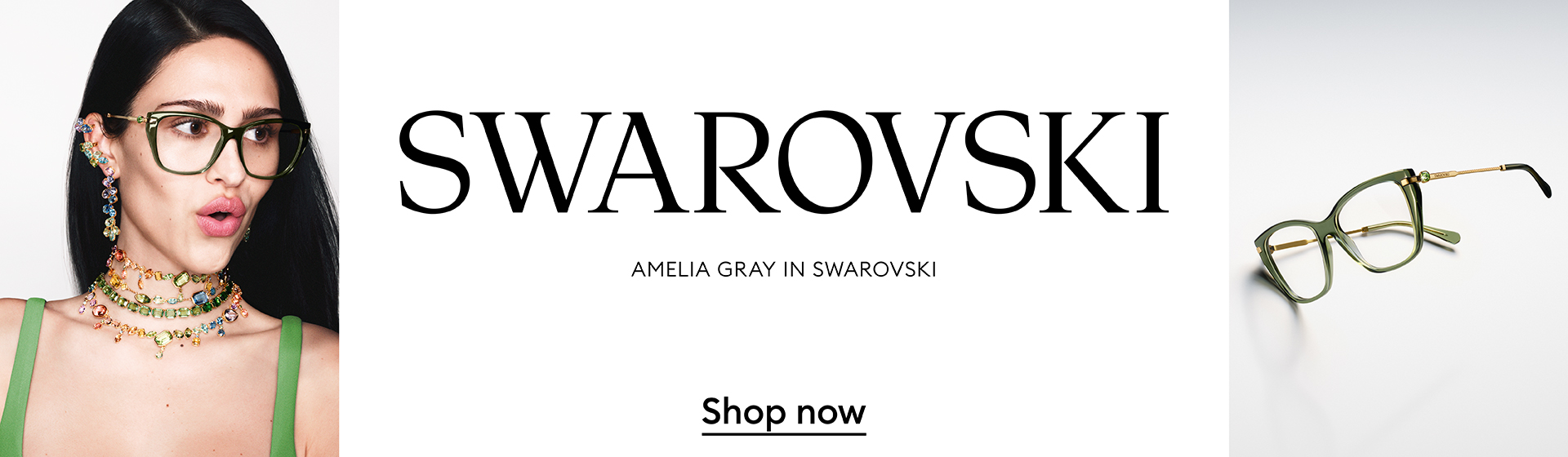 Kobieta w okularach i biżuterii, stojąca obok ogromnych okularów.