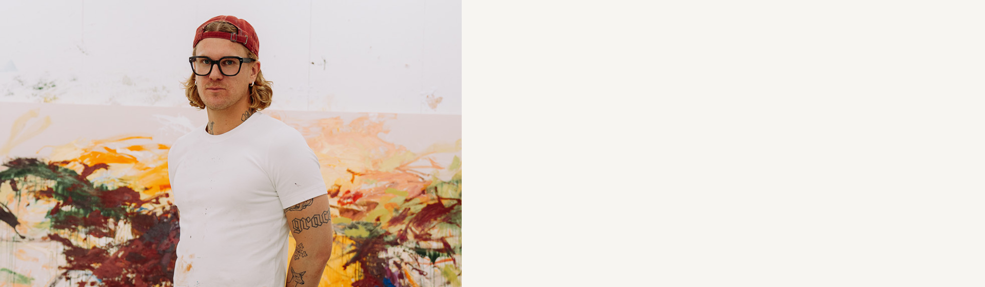L’artista Peter-Maximilian Ronsdorf nel suo studio davanti a un grande dipinto colorato.