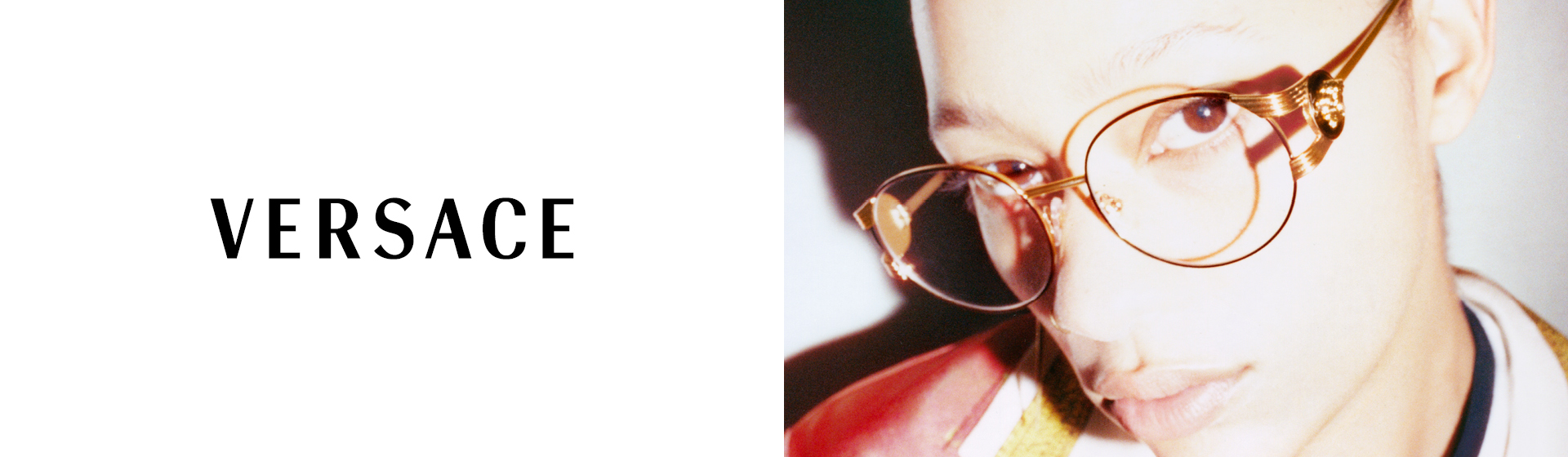 Person trägt eine goldene Versace-Brille und eine rote Jacke. Das Versace-Logo befindet sich auf der linken Seite des Bildes.