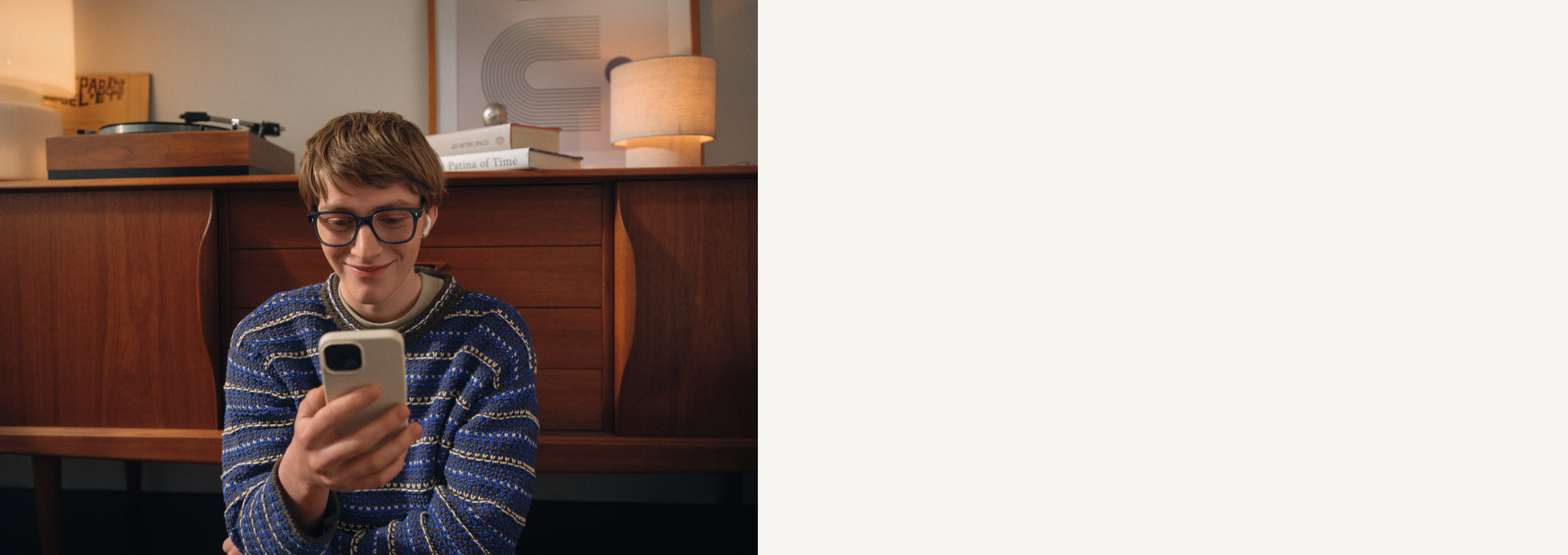 Ein Mann mit Brille und Kopfhörern schaut auf sein Smartphone.