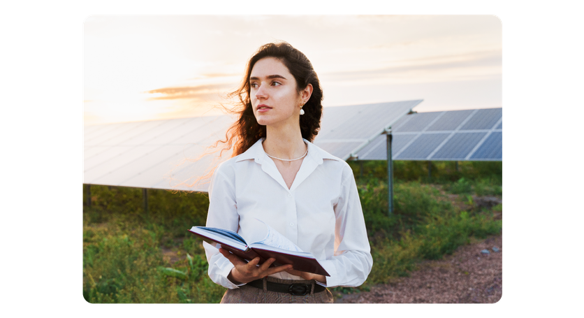 Une femme se tient devant des panneaux solaires avec un livre