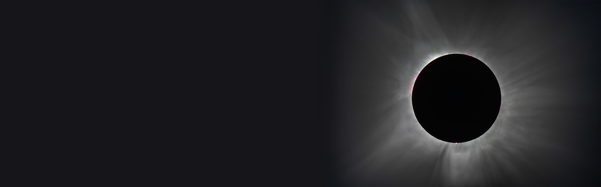 A total solar eclipse with a darkened sun and a bright corona surrounded by a soft radiating glow.