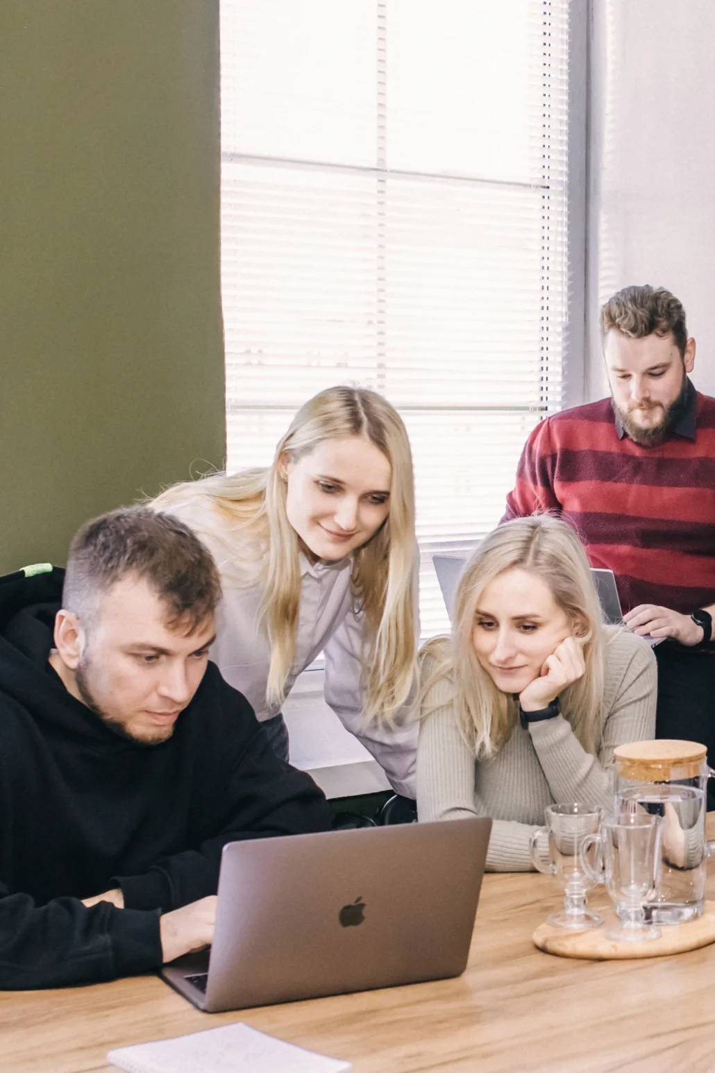 two men and two women are working on laptops