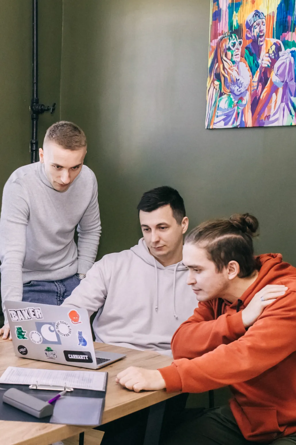 three developers are reviewing code on a laptop