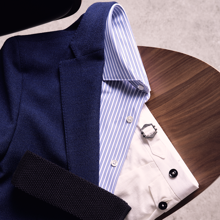 Overhemd, colbert en chino opgevouwen op tafel