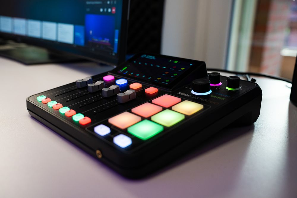 Streaming-Mischpult mit beleuchteten Tasten und Reglern auf einem Schreibtisch
