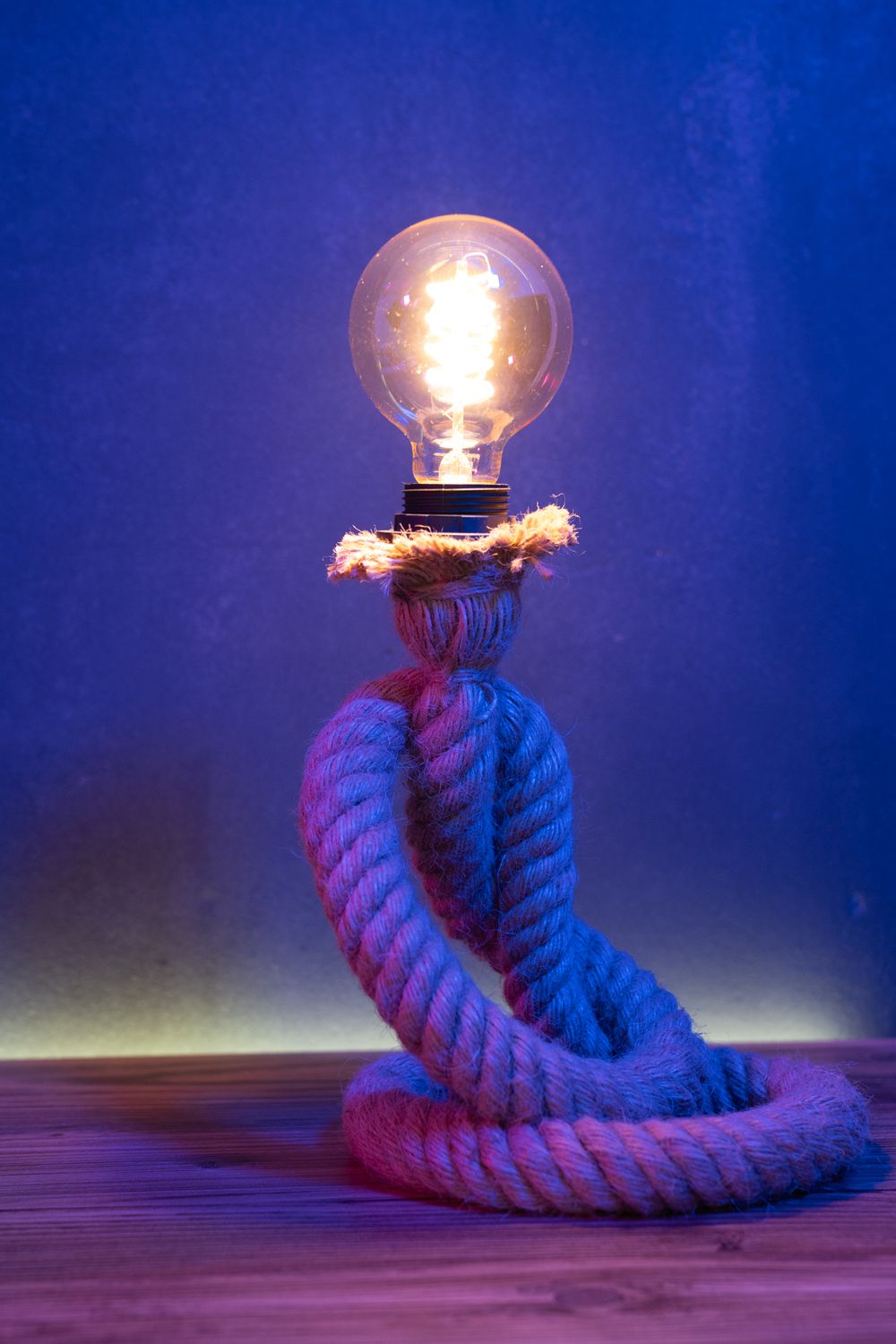 An old-school light bulb, held up by gravity-defying ropes.