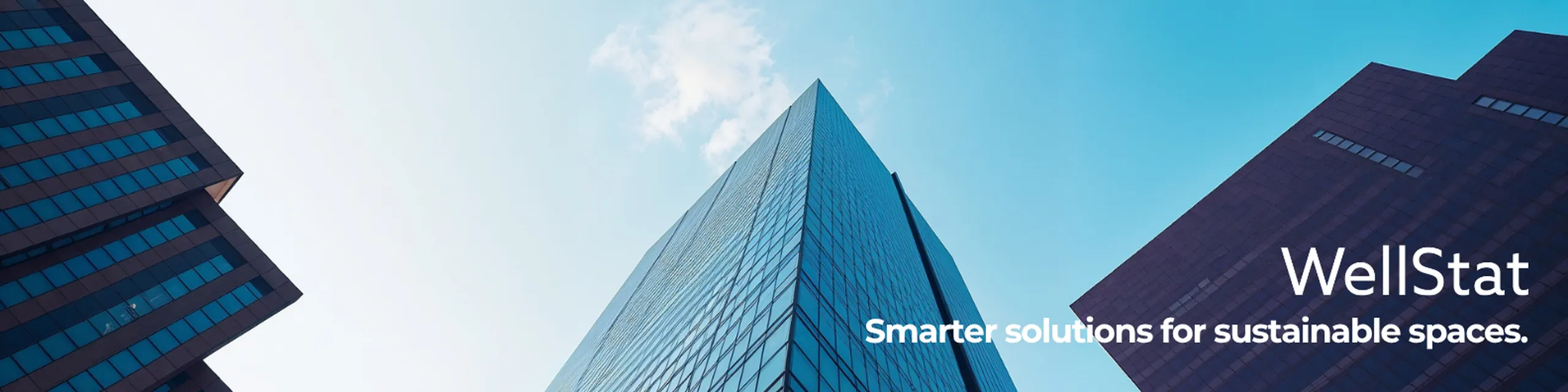 Skyscraper view from below against a clear sky. Text reads "WellStat: Smarter solutions for sustainable spaces."