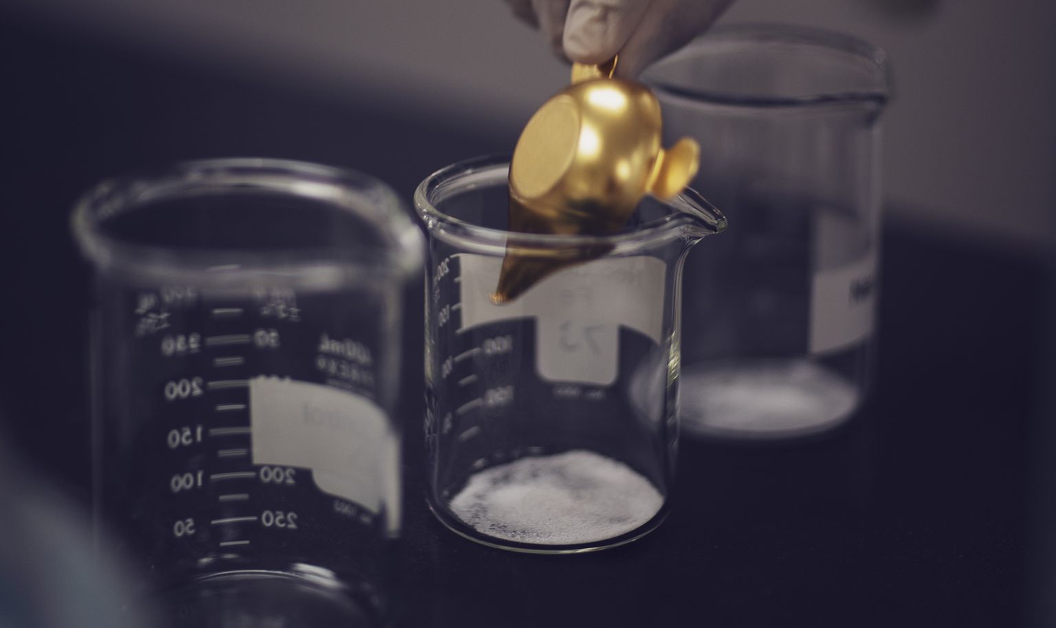 Small amounts of borates being poured into beakers for testing