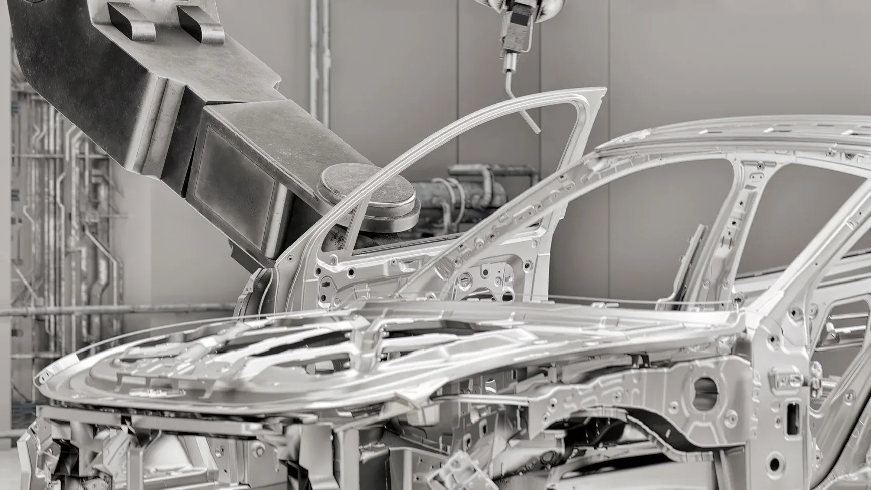 A robotic arm works on an unfinished car frame in an automated manufacturing facility.