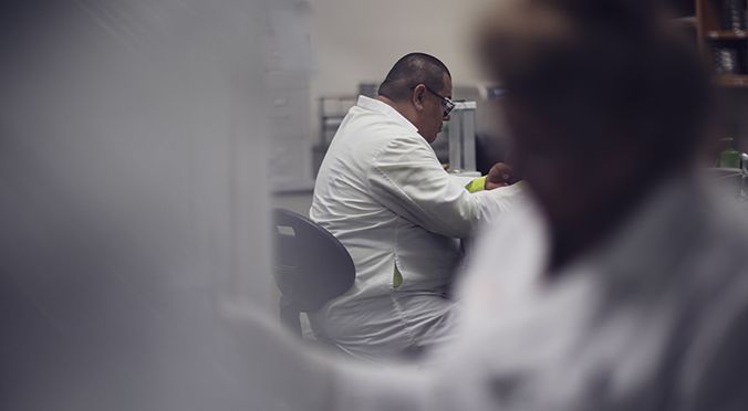 Male technician in the U.S. Borax lab with another technician in front.