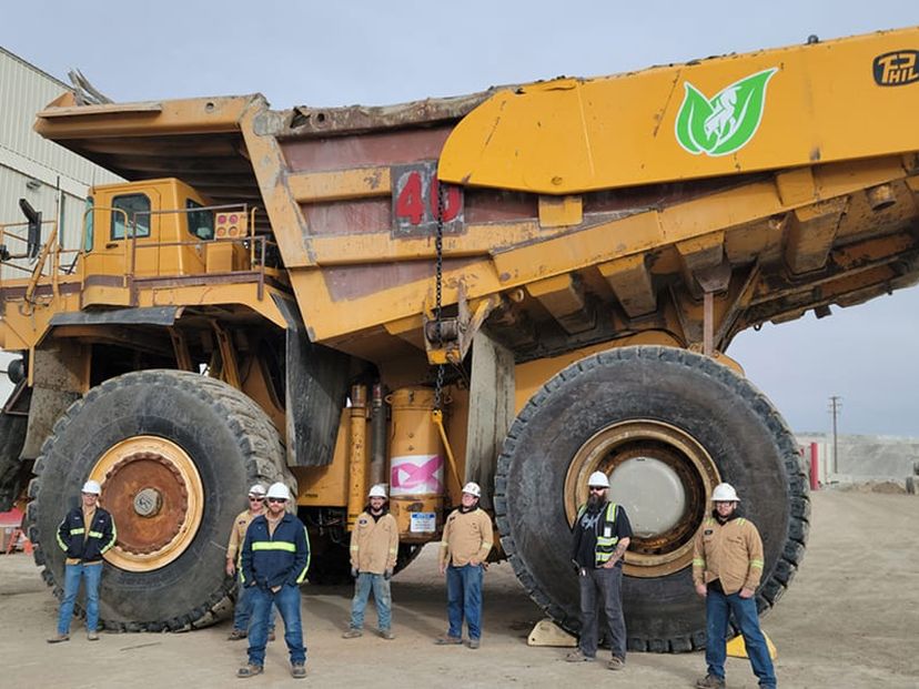 Renewable Diesel 2021 - Giant Dumptruck with workers standing in front of it.