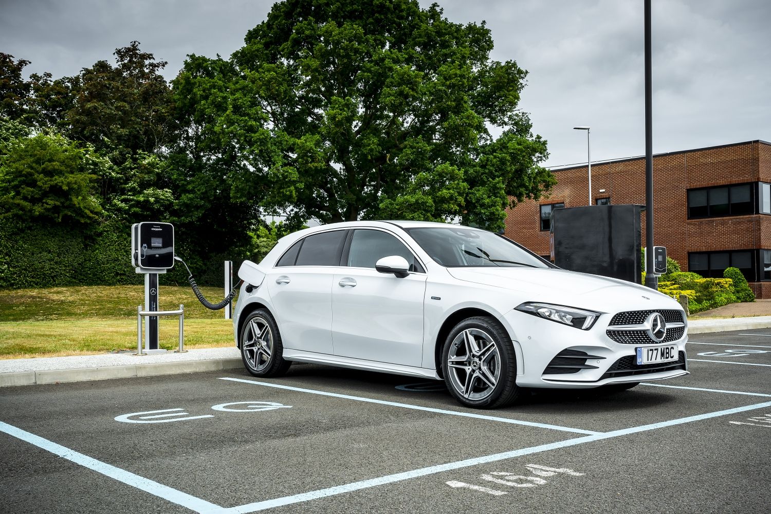 A white Mercedes A 250 e plugged in and charging