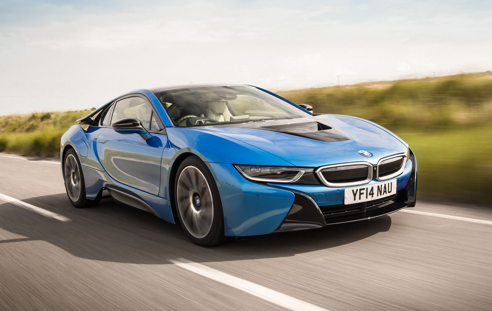 a blue bmw i8 driving on a road