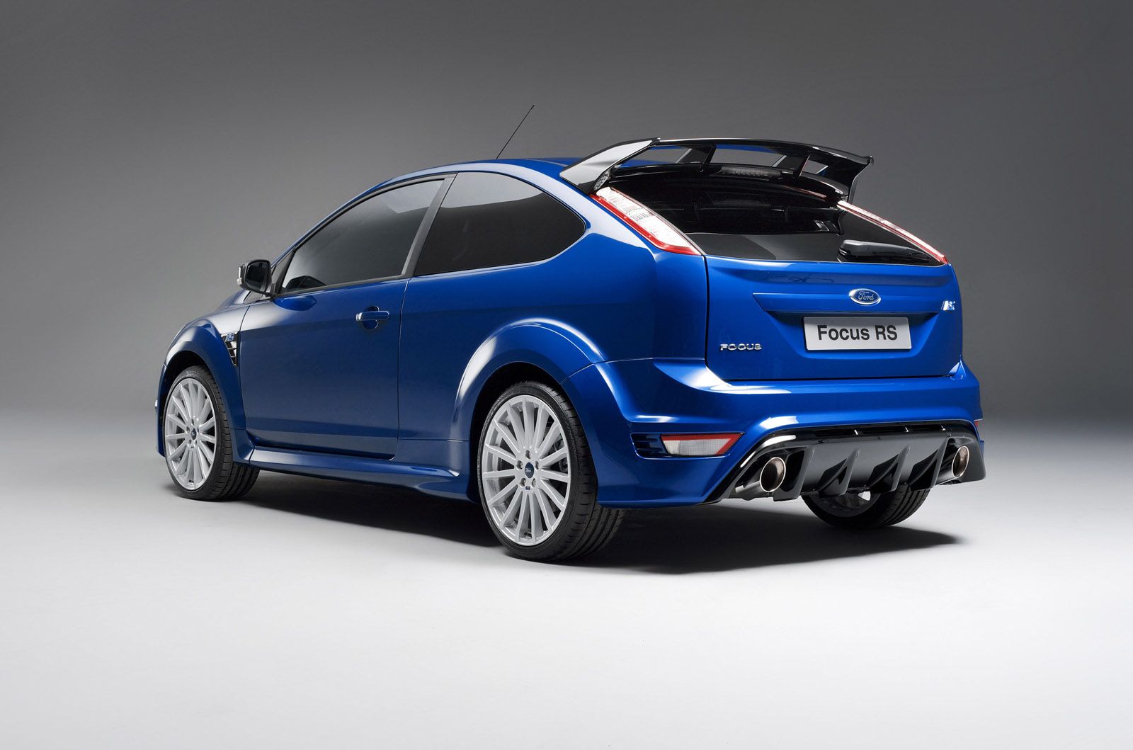 Blue Ford Focus RS sports car, rear view on a plain gray background, highlighting aerodynamic features and sleek design.