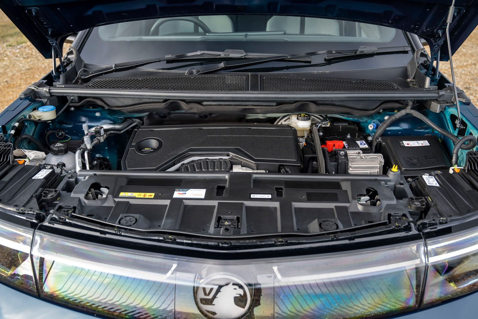 Open car hood showing a neatly arranged engine compartment with various components and labels visible.