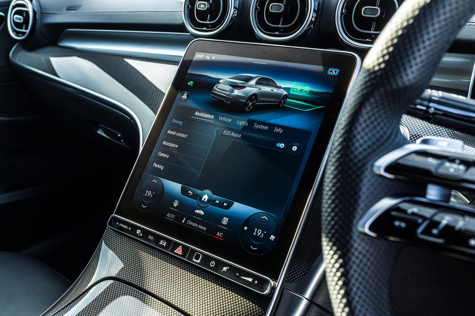 Car interior displaying a modern touchscreen infotainment system with vehicle settings and climate control options visible on the screen.