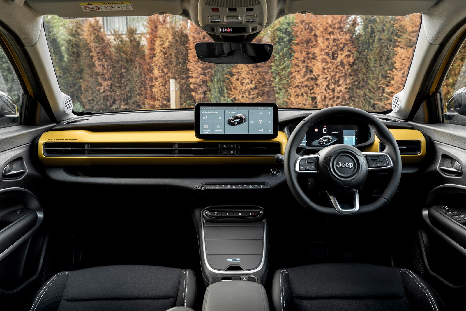 Jeep interior with black and yellow design, featuring a digital dashboard and touchscreen display, steering wheel in focus.