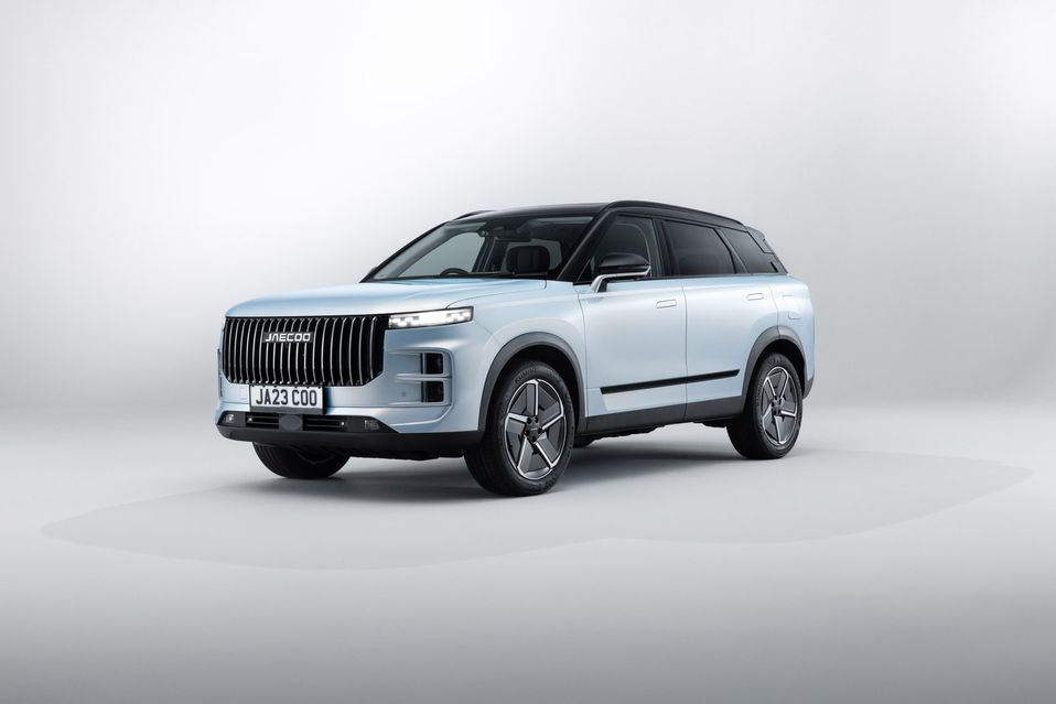 A sleek, modern SUV with a silver body and black roof, displayed in a minimalistic studio setting.