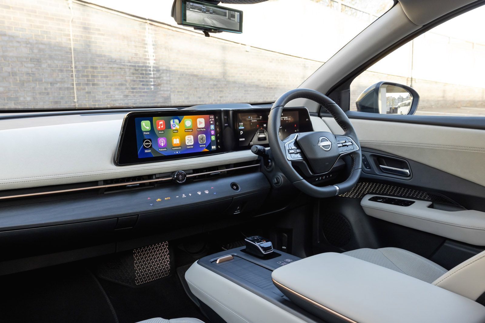Nissan Ariya interior showing steering wheel and Apple CarPlay