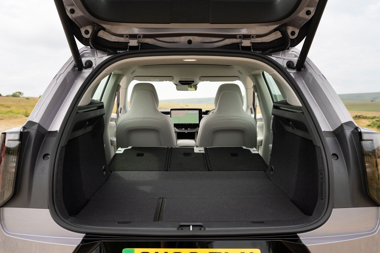 View of an open car trunk with rear seats folded down, offering a spacious and flat storage area.