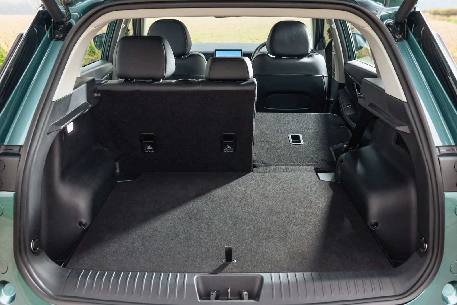 Open JAECOO 5 boot showing spacious cargo area with folded rear seats, black upholstery, and a view of the interior seating.