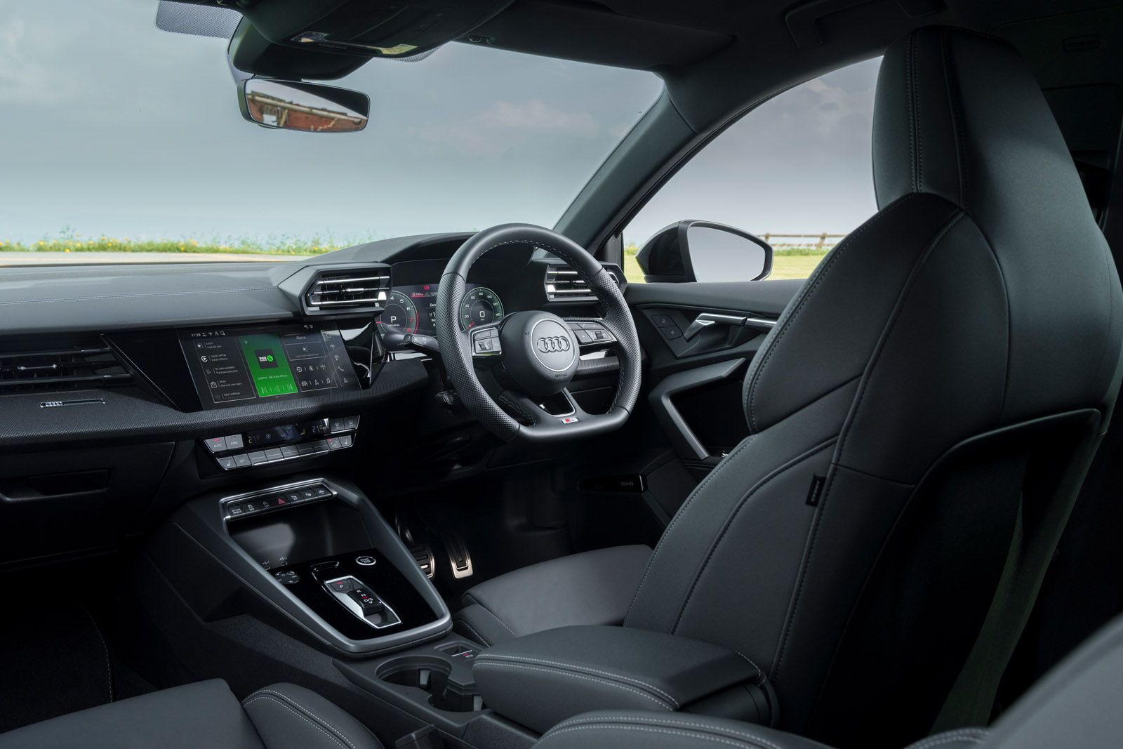 Interior of a modern car with a sleek dashboard, digital display, multifunction steering wheel, and comfortable black leather seats.