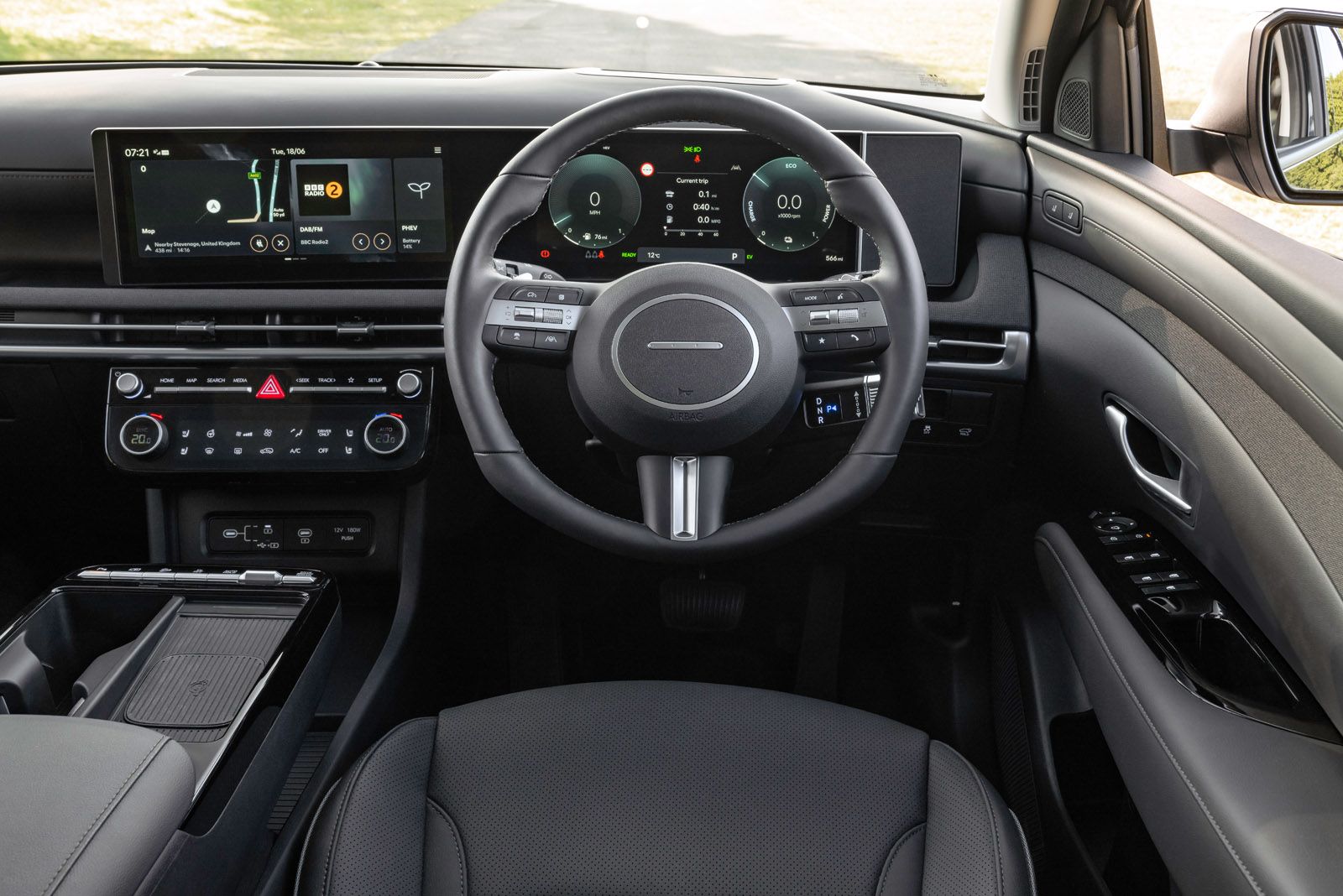 Car interior featuring a modern dashboard with digital displays, a multi-function steering wheel, and sleek controls.