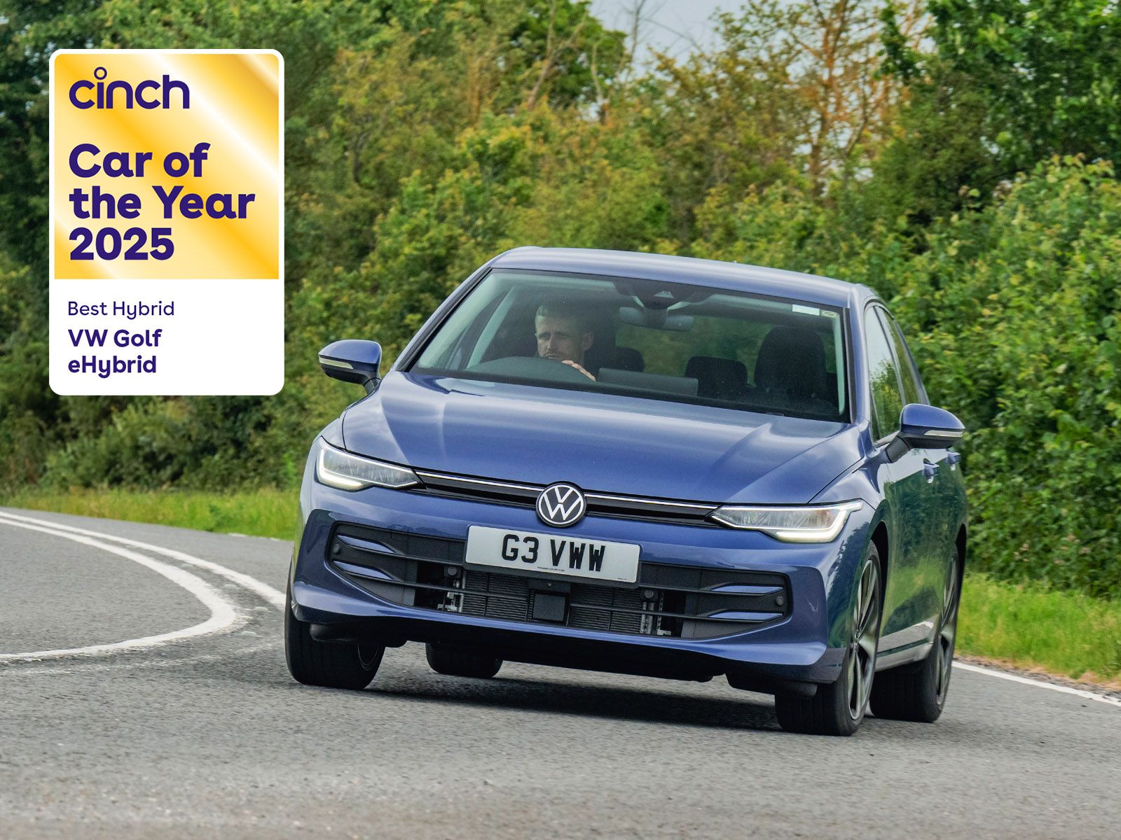 A blue VW Golf eHybrid driving on a curved road, awarded "Car of the Year 2025" for Best Hybrid by Cinch.
