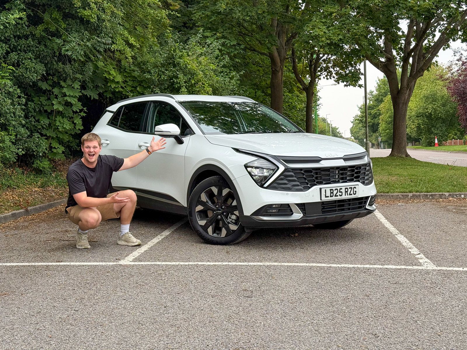 Ben Welham and a white Kia Sportage in a car park