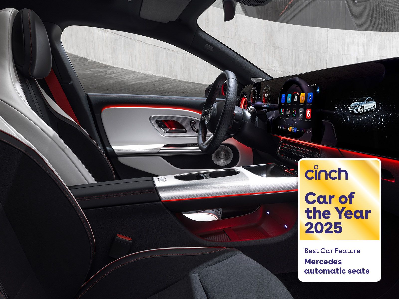 Interior of a modern car with illuminated dashboard and seats. "Cinch Car of the Year 2025" badge highlighting Mercedes automatic seats.