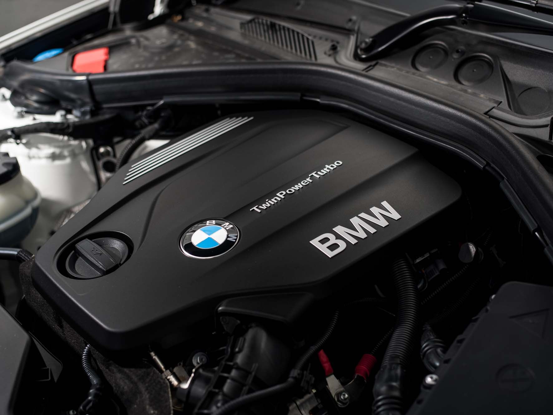 Close-up of a BMW TwinPower Turbo engine with a visible logo and sleek design under the car bonnet.