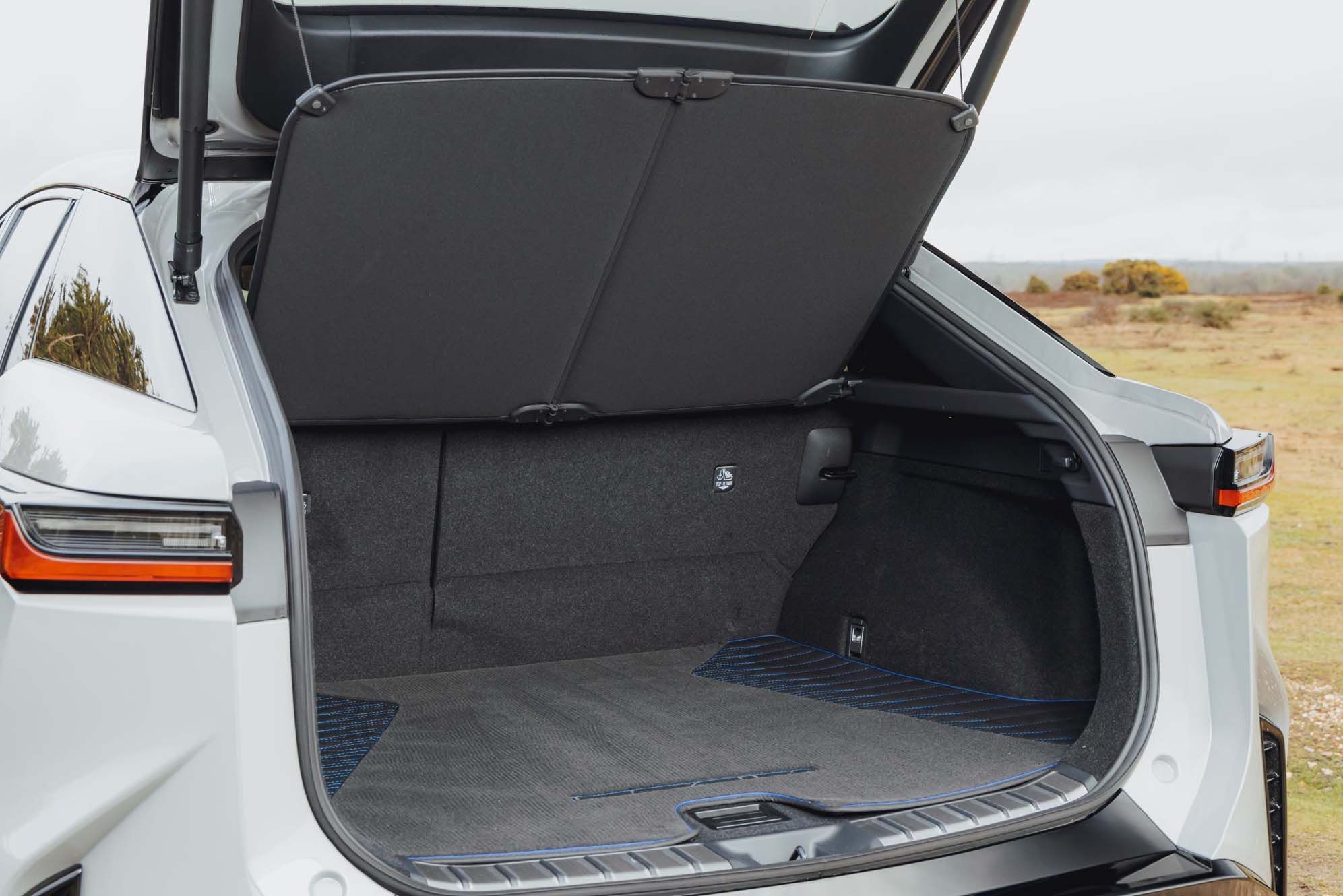 Open boot of a silver Lexus RZ, showing a spacious and clean cargo area with a cover and interior carpeting.